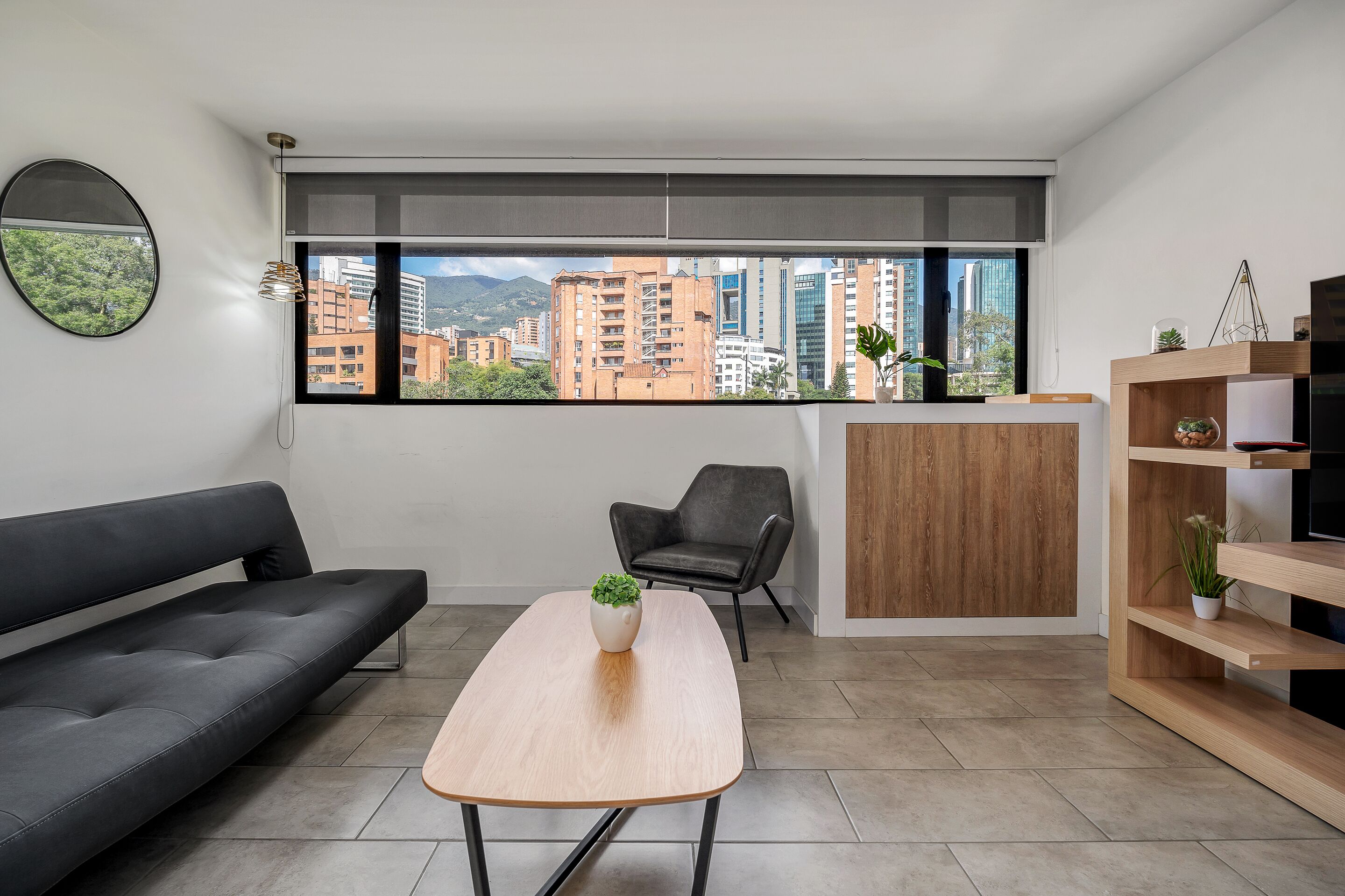 A modern living room with a sofa, a coffee table, a chair, a wooden cabinet, and a TV stand.