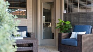 An outdoor seating area with wicker furniture and a potted plant. - Luxury Home Sleeps 20 with Heated Pool & Billiard (Dallas)