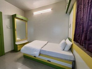 Cozy retreat with a single bed, full-length mirror, and simple design.