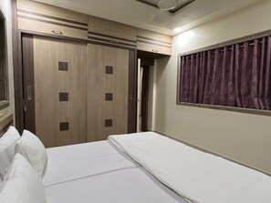 Enjoy a restful stay in this stylish room featuring a comfortable bed, modern wardrobe, and serene window views.