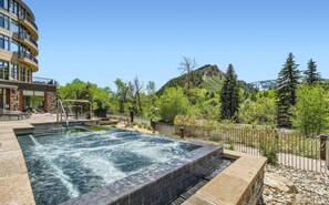 A spa area with a hot tub, outdoor seating, and a mountainous backdrop. - Charlie Rentz: Penthouse, 2,000+ Sq Ft, Panoramic Views, Ski-In/Out, 2 Balconies + Resort (Avon)