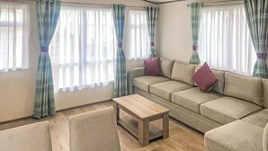 Ein Wohnzimmer mit einer Couch, einem kleinen Tisch und einem Sessel.