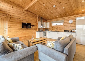 Un intérieur chaleureux de chalet en bois, comprenant un espace de vie, une cuisine et un coin repas.