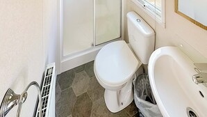 Une salle de bain avec des toilettes, une douche et un lavabo.
