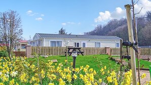 A mobile home with a fenced yard and a picnic table. - 2 bedroom accommodation in Gwespyr, Nr Prestatyn, Denbighshire (Gwespyr, Nr Prestatyn, Denbighshire)