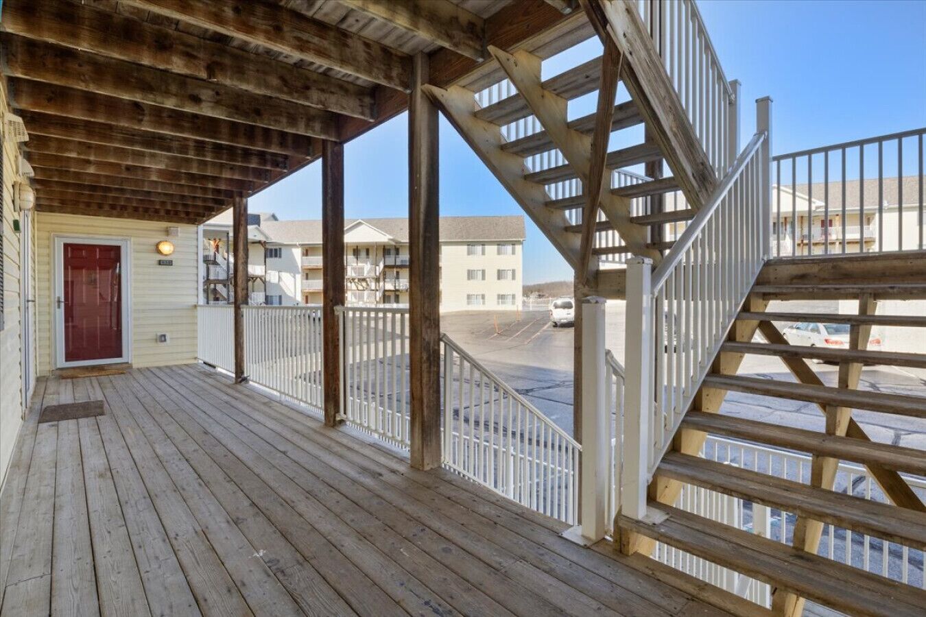 A wooden deck with a staircase leading to a building.