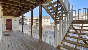 A wooden deck with a staircase leading to a building.