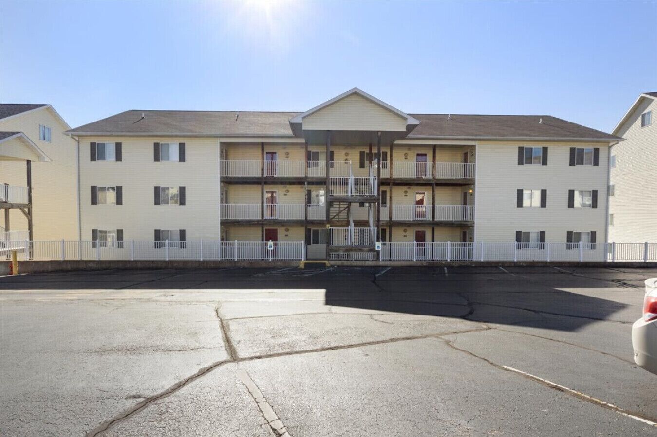 A multi-story motel with a central courtyard, balconies, and a parking lot.