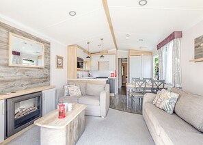 Una sala de estar moderna con chimenea, sofá y comedor.