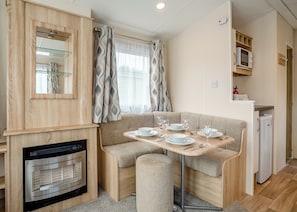 A compact kitchenette with a microwave, a small refrigerator, and a built-in oven.
