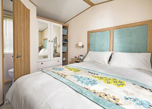 Ein Schlafzimmer mit einem Bett, einem Kleiderschrank, einem Spiegel und einem Nachttisch.