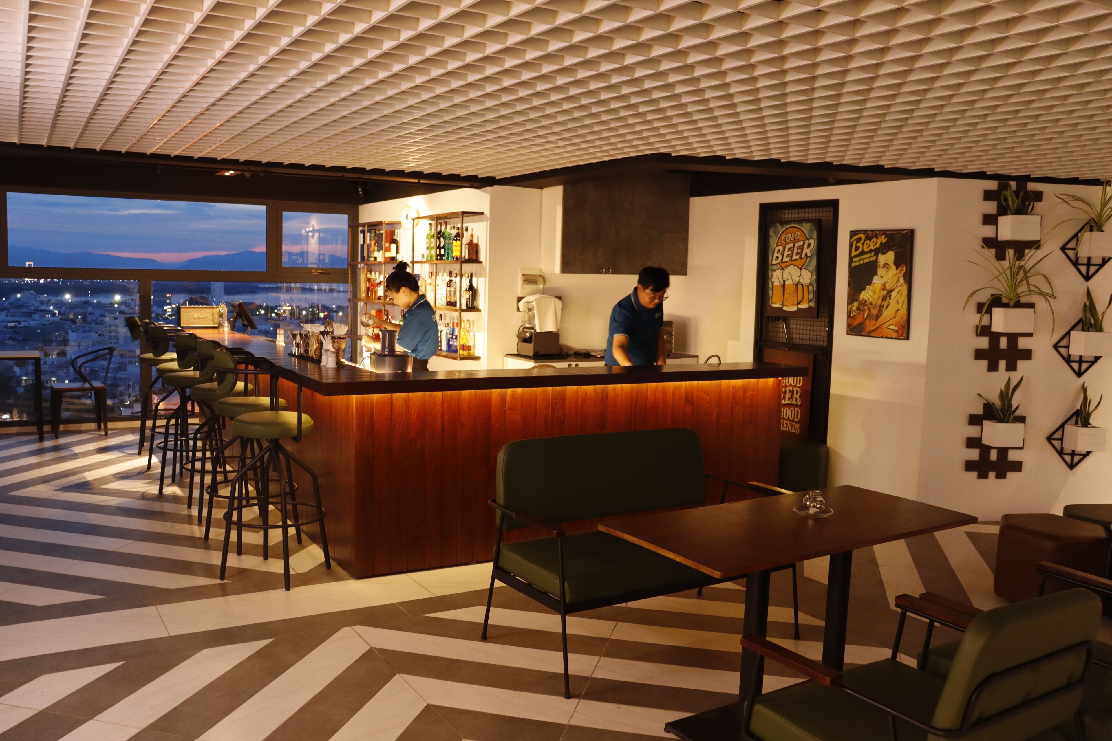 A bar area with a city view, bar stools, a counter, and a seating area with a table and chairs.