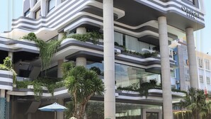 Un hotel moderno con un diseño arquitectónico único, con balcones curvos y jardines verticales.