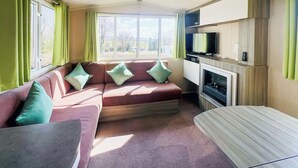 Un espacio habitable pequeño con un sofá, un televisor y una chimenea.