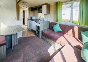 A compact living space with a kitchenette, a sofa, and a dining table.