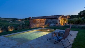 A stone house with a swimming pool, outdoor seating, and a well-lit garden at dusk. - Country House Lo Spigo 4 (Barberino Tavarnelle)