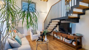 A modern living room with a staircase, a sofa, a coffee table, and a bookshelf. - Country House Lo Spigo 4 (Barberino Tavarnelle)