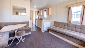 A compact RV interior with a kitchenette, a dining area, and a living space. - 12ft-wide caravan with one double and two twin. (Bognor Regis)
