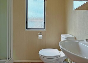 Ein Badezimmer mit Toilette, Waschbecken und Fenster.