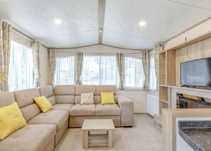 A living room with a sofa, a coffee table, and a television on a stand.