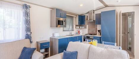 A compact living space with a kitchenette, a sofa, and a dining table.