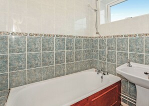 A bathroom with a bathtub, a sink, and a shower. - Bungalow with one double and one twin. (Trearddur Bay, Holyhead)