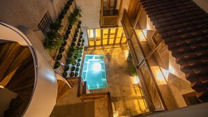 A courtyard with a glass-bottomed pool, wooden railings, and potted plants. - 5 Bedroom Luxury Villa in Old City (Cartagena)