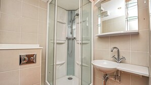 A modern bathroom with a glass-enclosed shower, a white sink with a chrome faucet, and a mirror above the sink. - 1 bedroom accommodation in Silloth (Silloth)