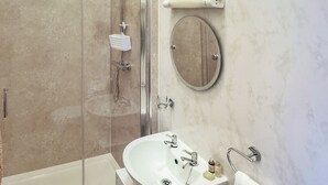 Un bagno con doccia, lavandino e specchio.