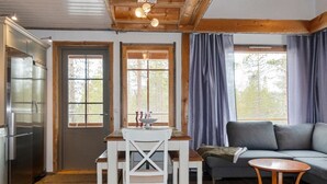 Un salon confortable avec un canapé, une table à manger et des chaises, ainsi qu’une petite table en bois.