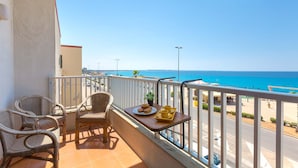 A balcony with wicker chairs and a table with a tray of food and drinks, overlooking a coastal road and the sea. - 3040 Appartamento Bludamare by Barbarhouse (Gallipoli)