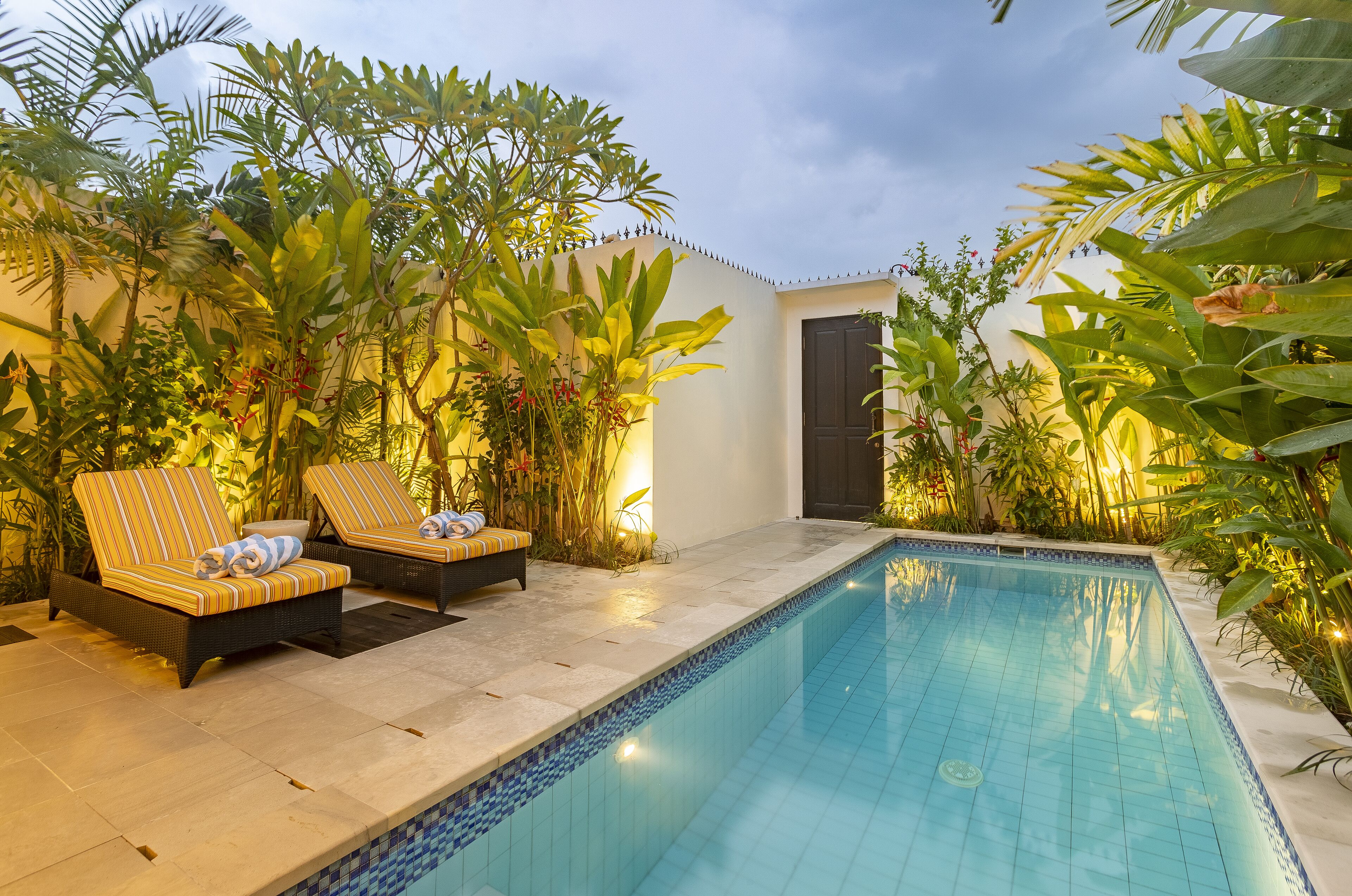 Alberca al aire libre y camastros 