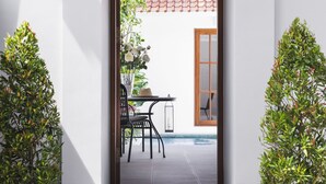 A staircase leading to a patio area with a table and chairs, surrounded by potted plants. - Villa Anahera (Seminyak)
