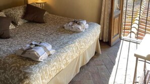 Un dormitorio con una cama, una mesita de noche, una lámpara y dos cuadros en la pared.