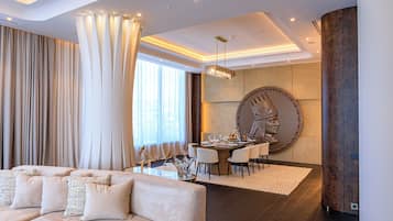 Ein modernes Wohnzimmer mit Sofa, Essbereich und einer großen Wanduhr.