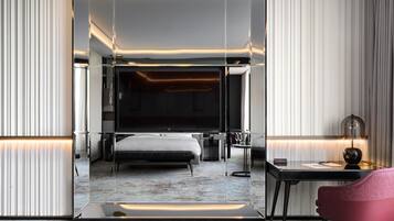 Una habitación de hotel moderna con una cama grande, un escritorio y una silla.