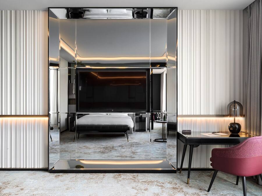 Una habitación de hotel moderna con una cama grande, un escritorio y una silla.