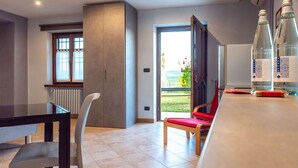 A modern kitchen with a dining area, a large window, and a view of the outdoors.