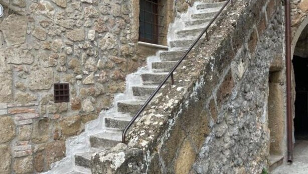 Eine Steintreppe führt zu einem Gebäude im rustikalen Stil.