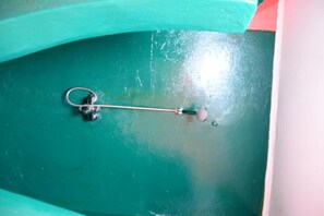 Een metalen sleutelhanger met een sleutel eraan, liggend op een blauwgroene ondergrond.