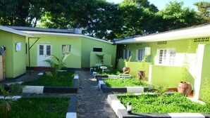 Une cour intérieure avec un chemin menant à un bâtiment portant l’inscription « UMUBANO ».