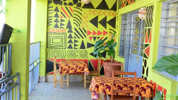 Un espace repas avec des tables et des chaises, une plante en pot et une fenêtre donnant sur un paysage agréable.