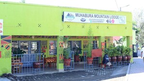 Un bâtiment sur lequel on peut lire l’inscription : « MUHABURA MOUNTAIN LODGE ».