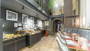 A modern dining area with a long counter, multiple seating options, and a variety of food items displayed. - Duomo Smart Suites (Milan)