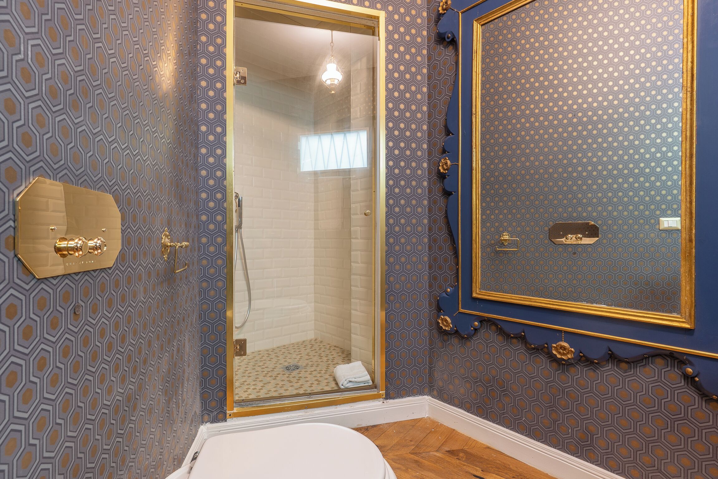 A bathroom with a shower, a toilet, and a vanity with a mirror.