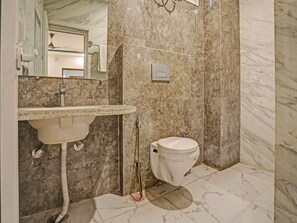 A bathroom with a marble sink, a toilet, and a mirror.