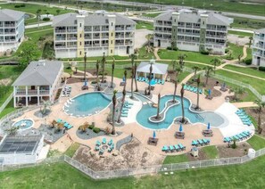 A resort with multiple swimming pools, lounge areas, and a large building with balconies.