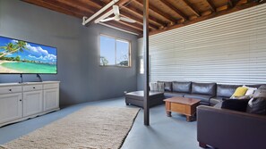 Relax in this stylish living room with a flat-screen TV, leather sofa, and wooden coffee table.