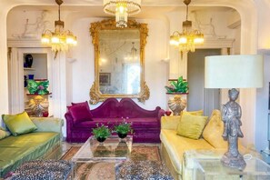 A room with a large mirror, two sofas, a coffee table, and decorative items.