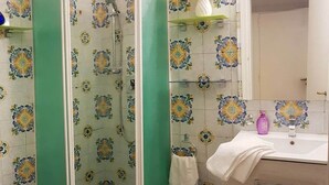 Ein Badezimmer mit Dusche, Waschbecken und Spiegel.